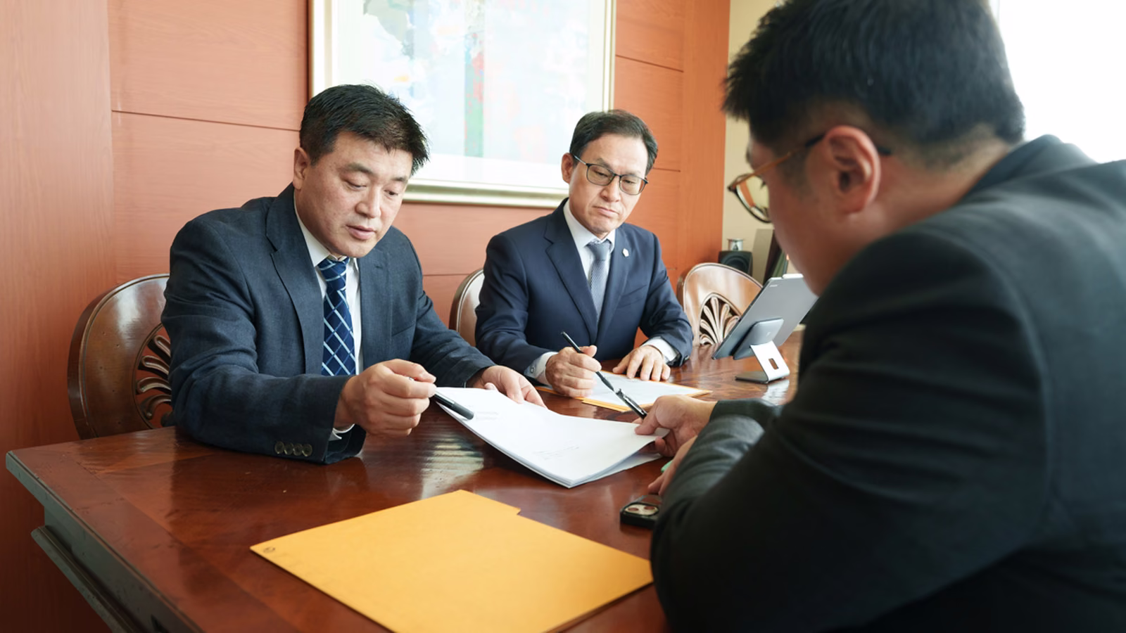 상담 테이블 위 서류를 두고 여러 사람이 자료를 함께 검토하는 모습